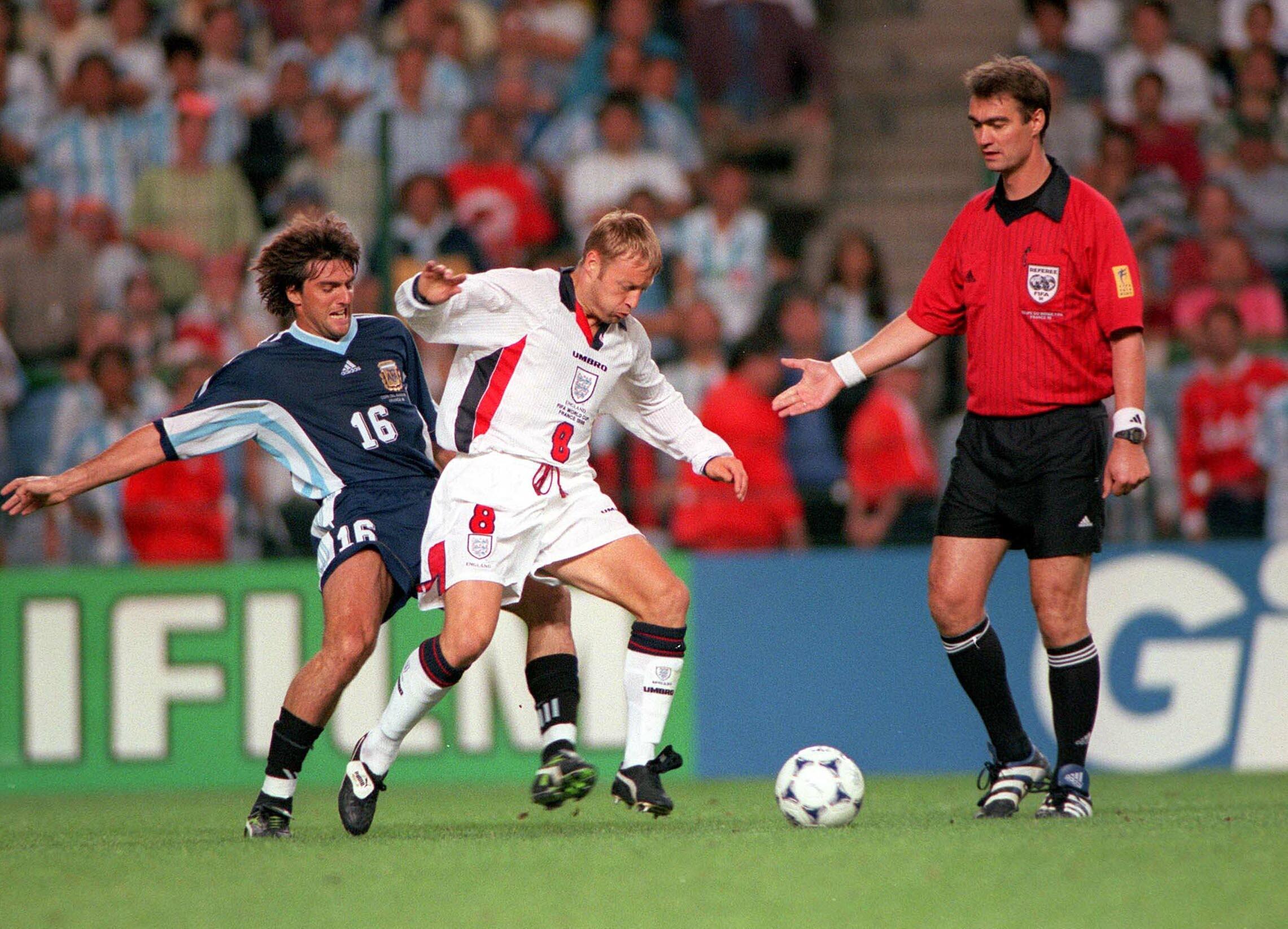 England’s David Batty takes the ball away from Argentina’s Sergio Berti as referee Kim Milton Nielsen watches on