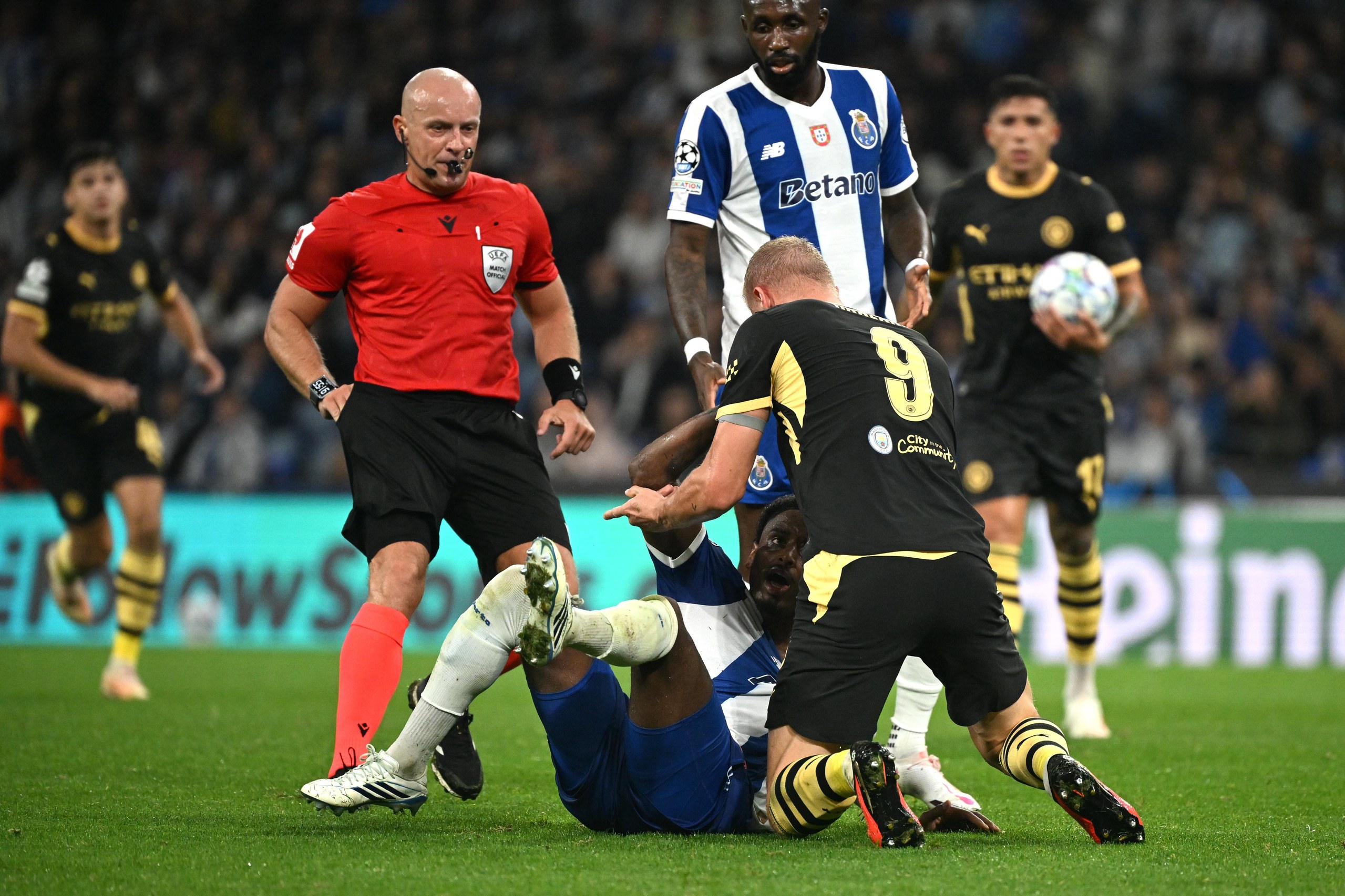 Referee Szymon Marciniak rushes in to separate Manchester City's Erling Haaland (right) and Porto's Pablo Rosario.