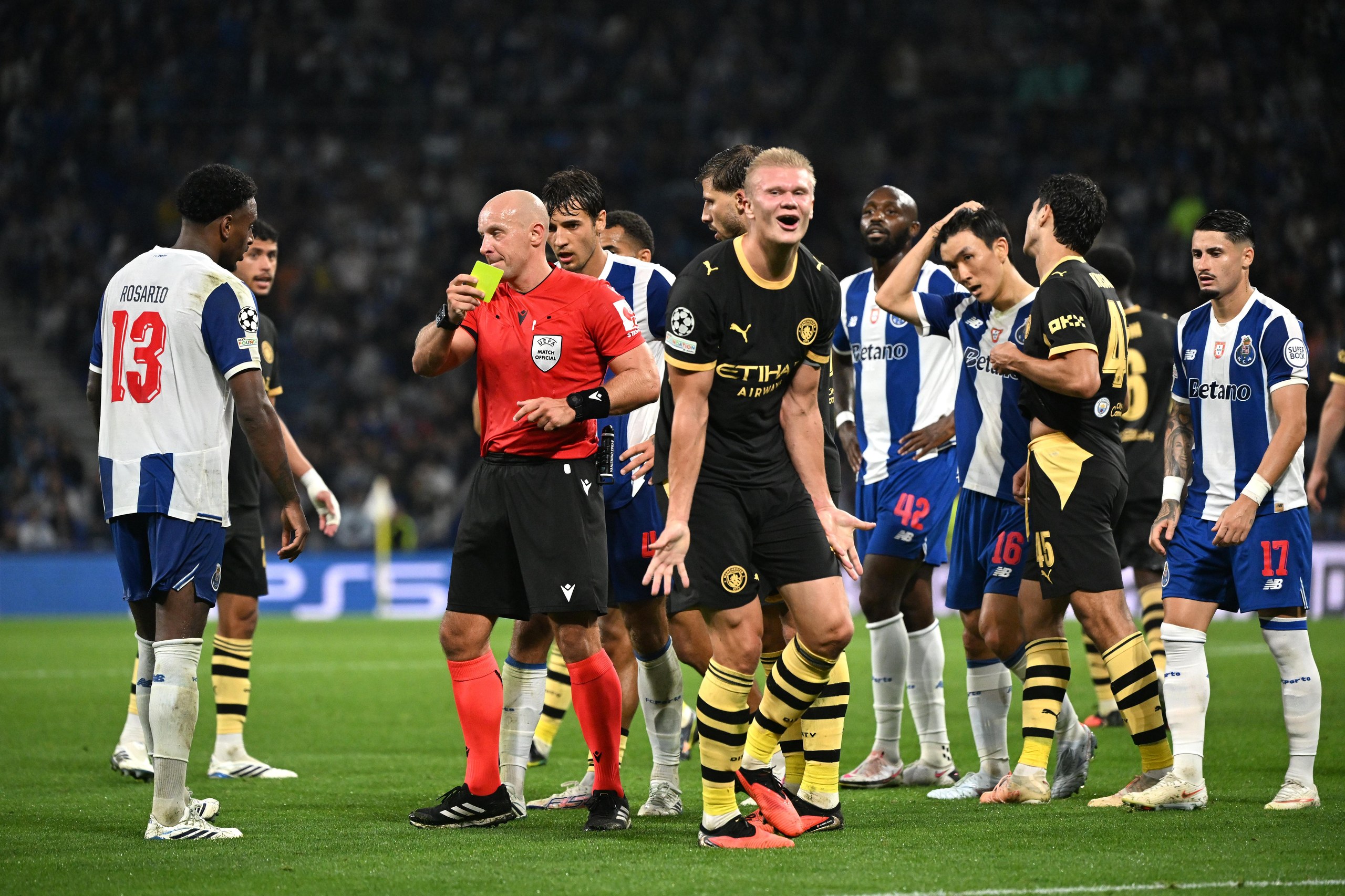 Manchester City's Erling Haaland reacts after being shown a yellow card by referee Szymon Marciniak following a clash with Porto's Pablo Rosario (left), who also received a yellow card.